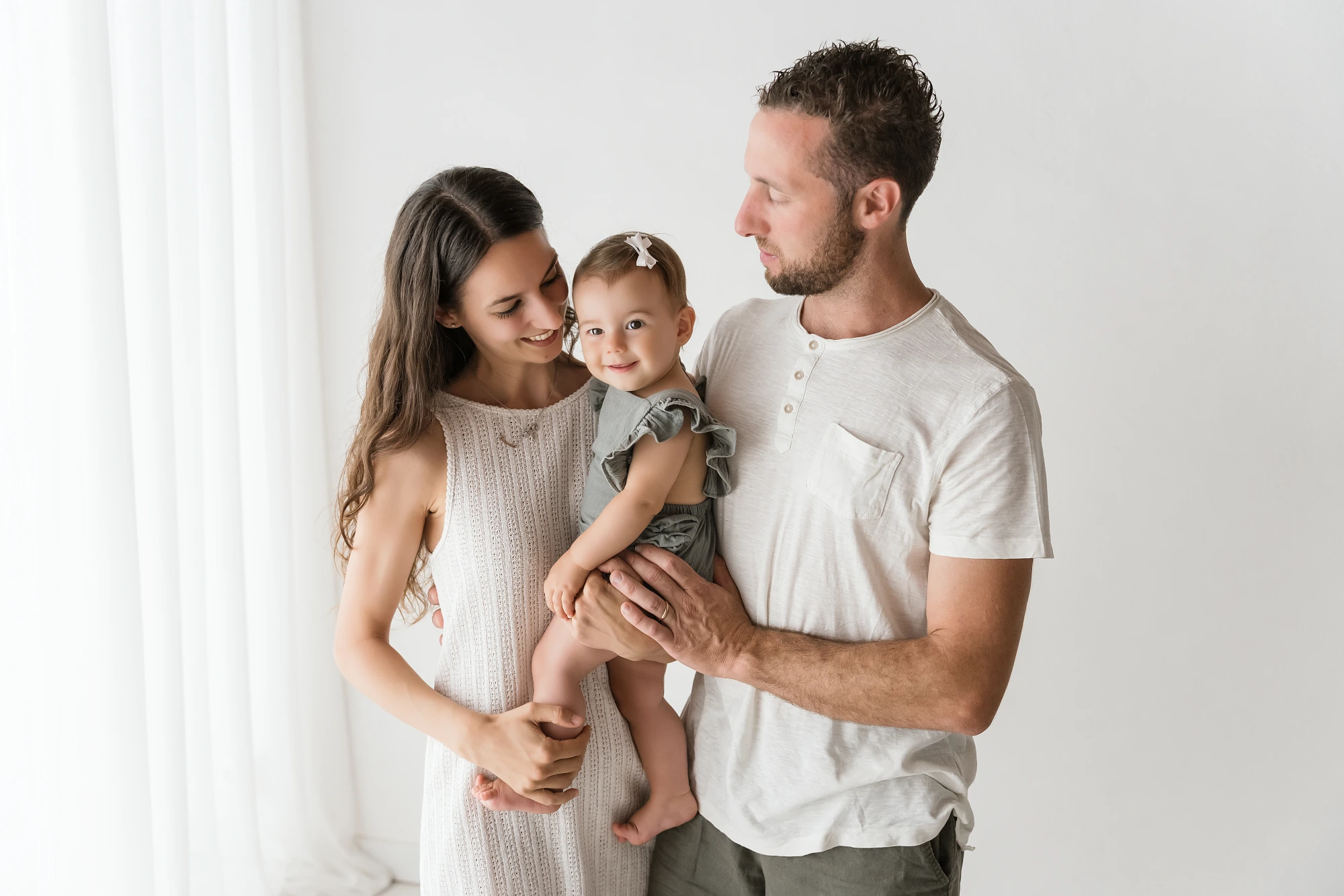 famiglia sorridente con bambina piccola in braccio