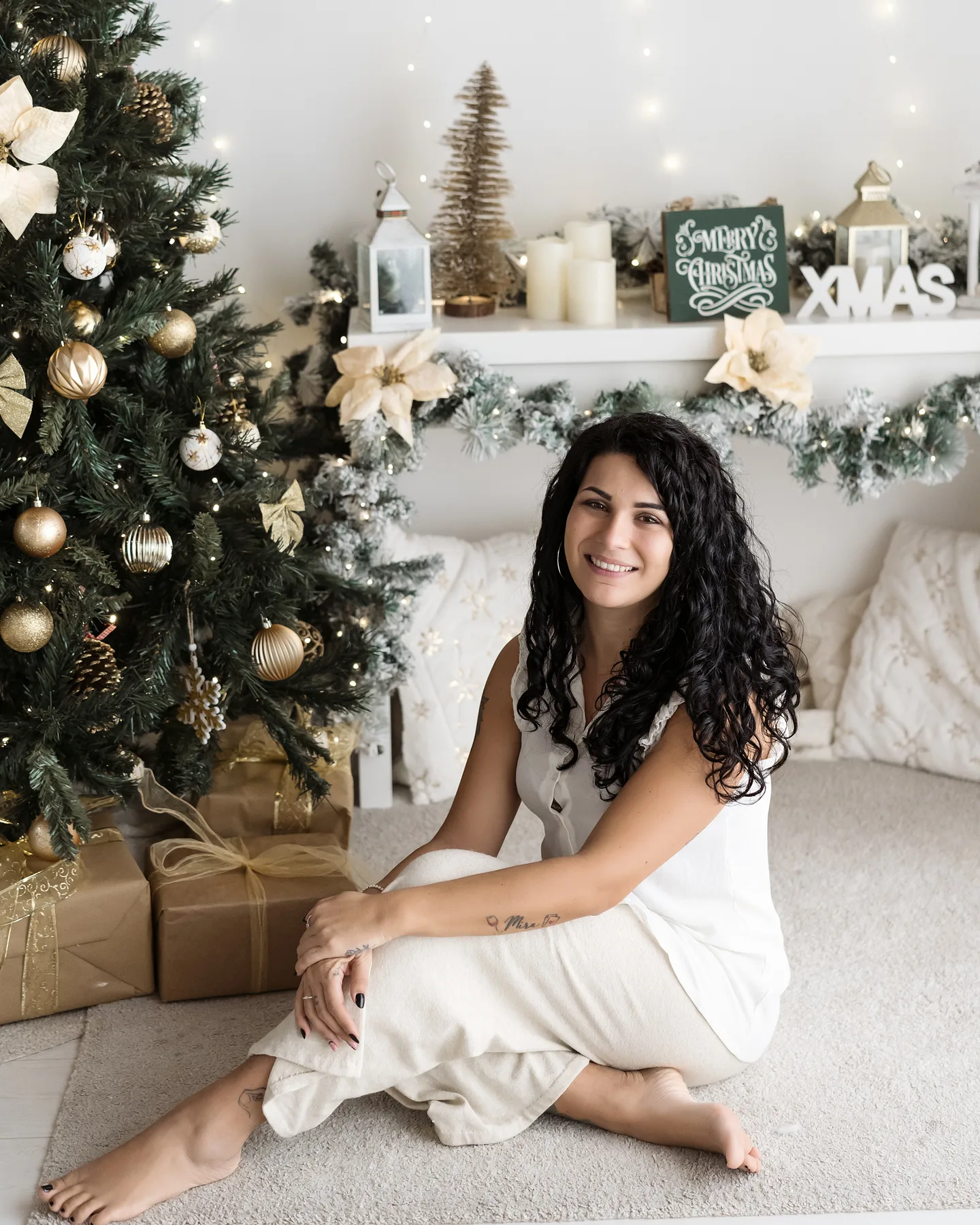 La fotografa Ilaria in un set di Natale: mensola con la scritta XMAS, candele e legno naturale nell'Atelier di Livorno